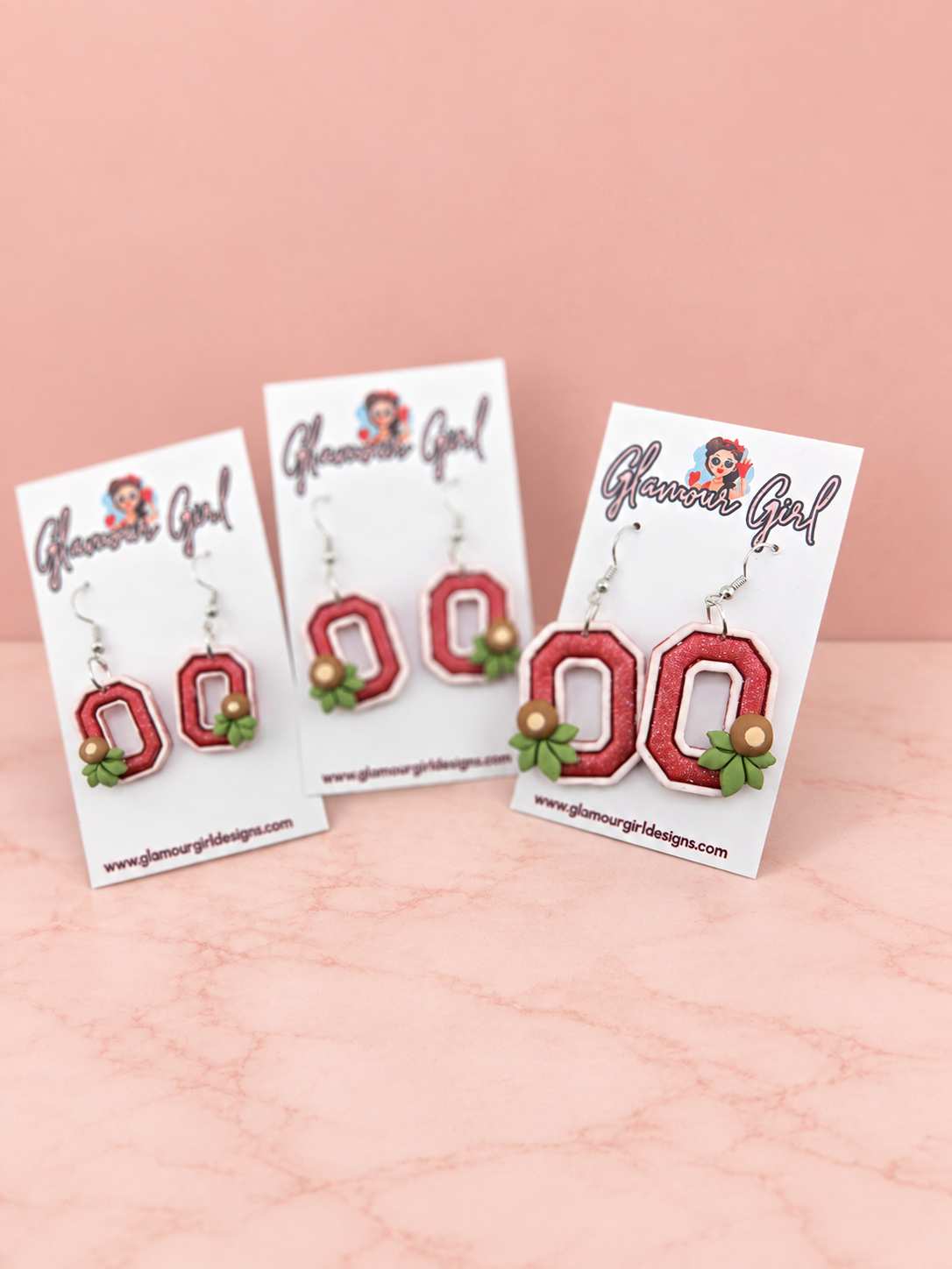 Buckeye helmet earrings second group view on blush pink background