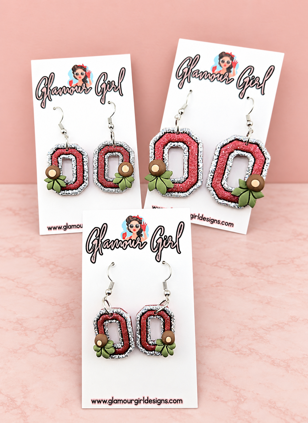 Scarlet Buckeye Block O earrings second group view on blush pink background