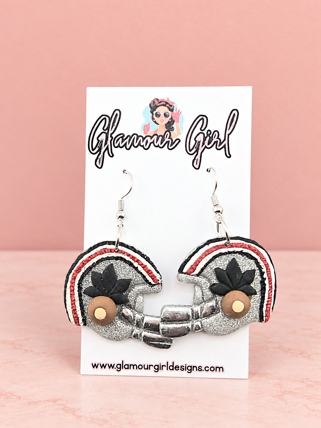 Buckeye helmet earrings on blush pink background